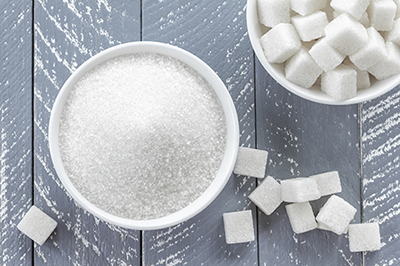 Bowl of granulated sugar and sugar cubes