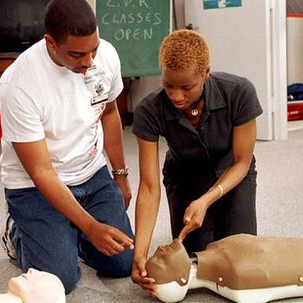 A black CPR instructor with her student